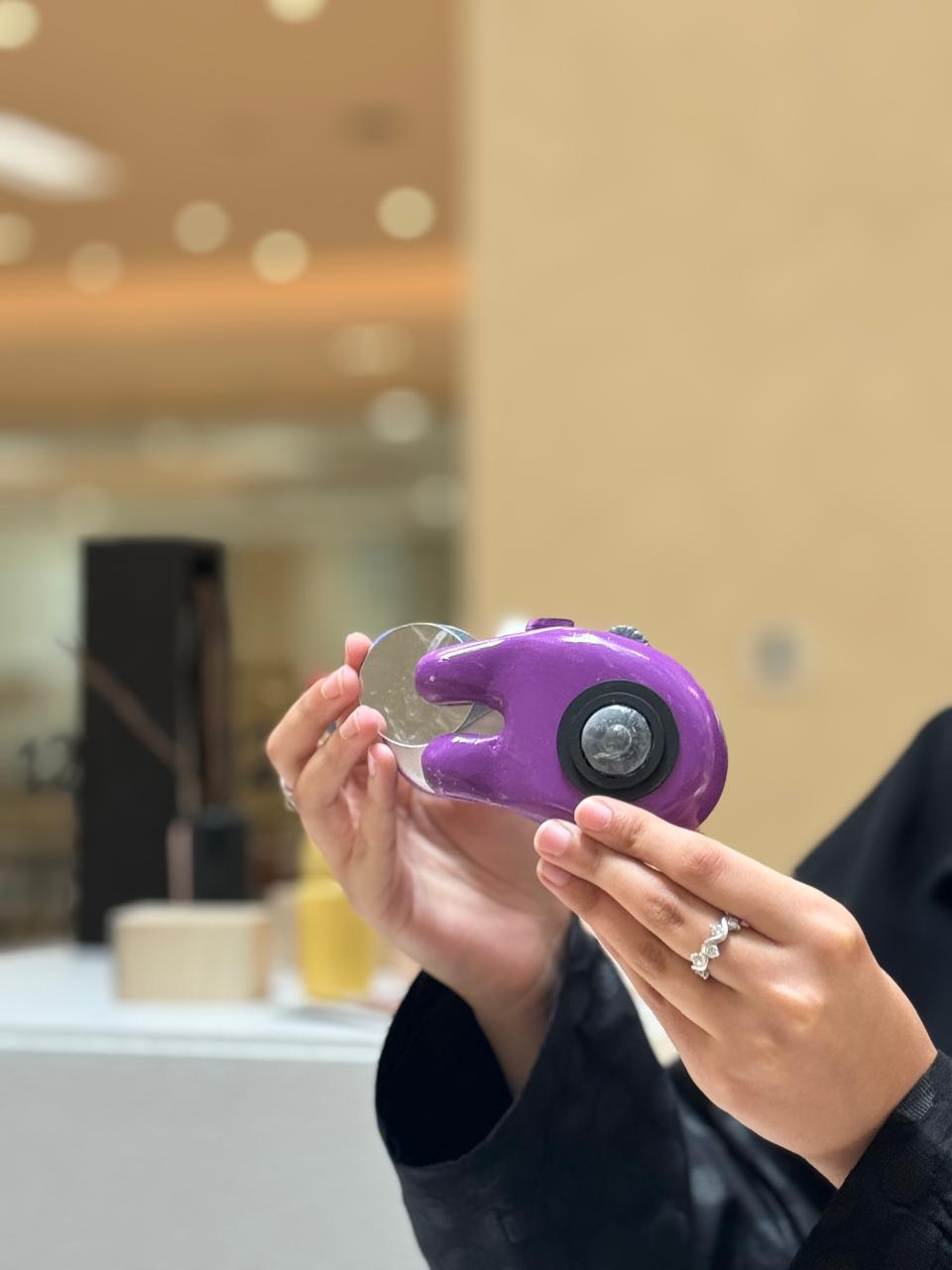 MIRAA final prototype held in hands, showing the sliding mirror pulled out and the lens facing the camera